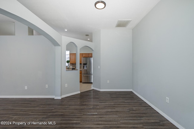 empty room with lofted ceiling and dark hardwood / wood-style floors