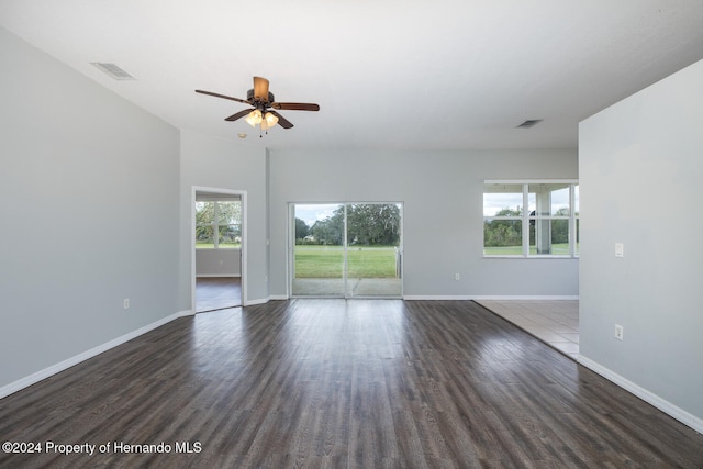 spare room featuring ceiling fan, dark hardwood / wood-style floors, and plenty of natural light