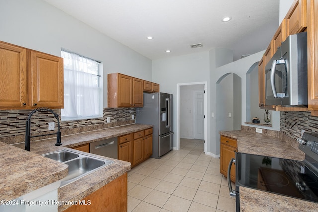 kitchen featuring appliances with stainless steel finishes, sink, tasteful backsplash, and light tile patterned floors