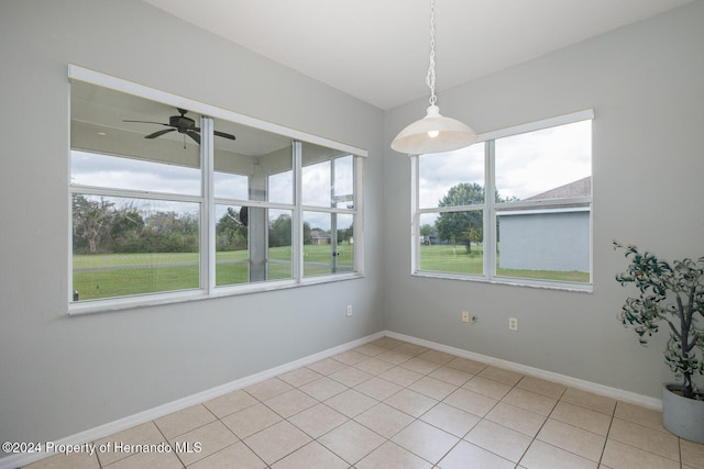 spare room featuring ceiling fan, light tile patterned floors, and a healthy amount of sunlight