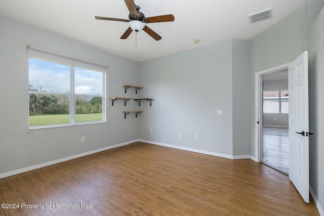 spare room featuring hardwood / wood-style floors, ceiling fan, and plenty of natural light