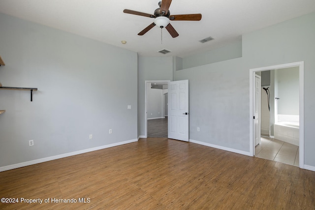 unfurnished bedroom with light hardwood / wood-style flooring, ceiling fan, and ensuite bath