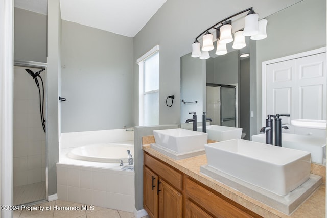 bathroom featuring tile patterned flooring, shower with separate bathtub, and vanity