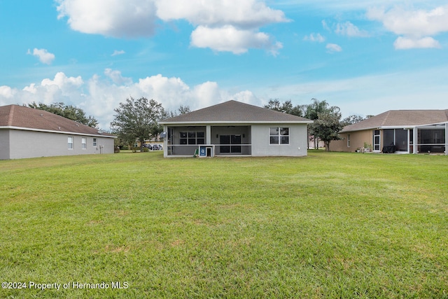 back of house with a sunroom and a yard