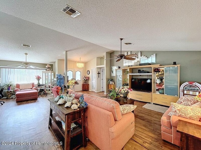 living room with hardwood / wood-style flooring, ceiling fan, a textured ceiling, and vaulted ceiling