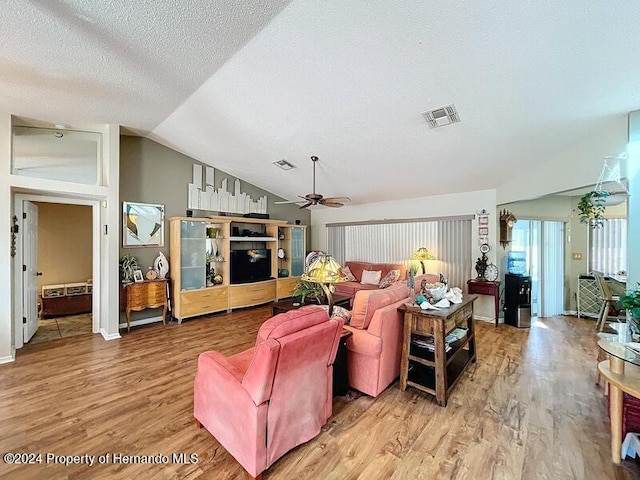 living room featuring lofted ceiling, wood-type flooring, ceiling fan, and a textured ceiling