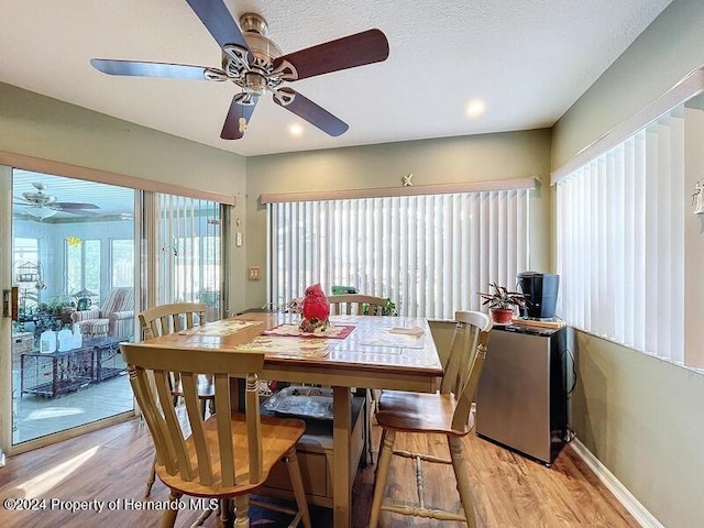 dining room featuring light hardwood / wood-style floors, ceiling fan, and a textured ceiling