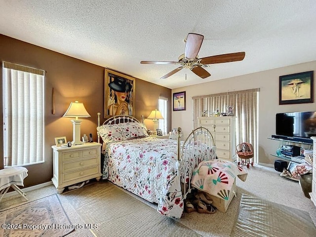 carpeted bedroom with a textured ceiling and ceiling fan