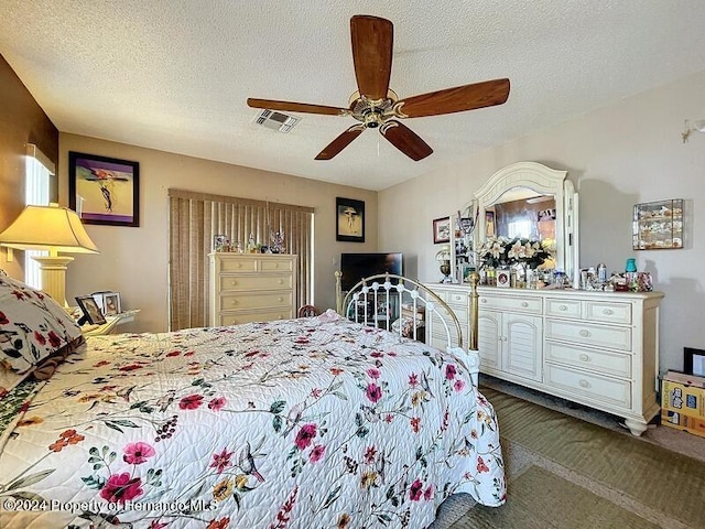 carpeted bedroom with a textured ceiling and ceiling fan