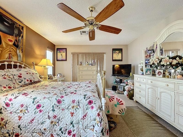 bedroom featuring a textured ceiling, ceiling fan, and carpet floors