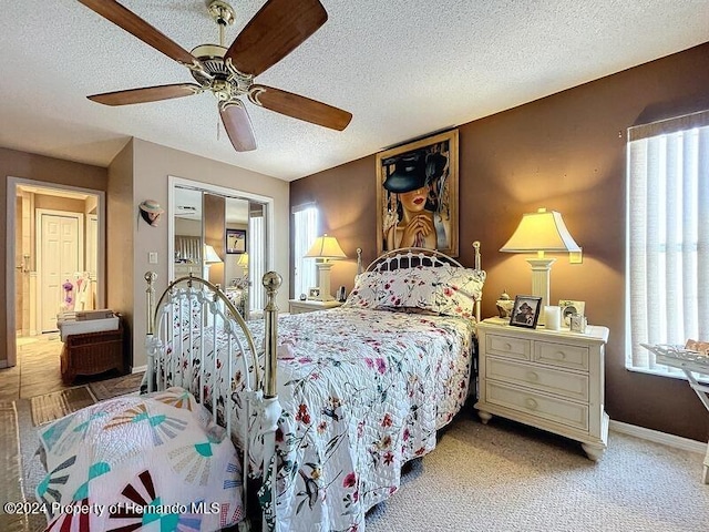 bedroom featuring ceiling fan, a textured ceiling, and carpet floors