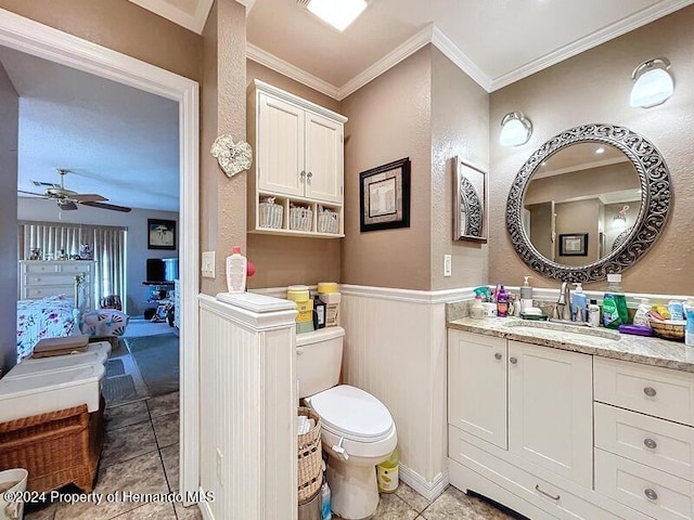 bathroom featuring ceiling fan, vanity, crown molding, tile patterned floors, and toilet