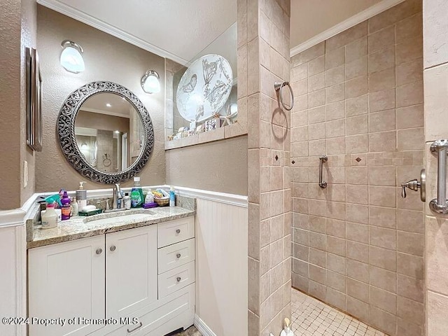 bathroom with vanity, a tile shower, and crown molding