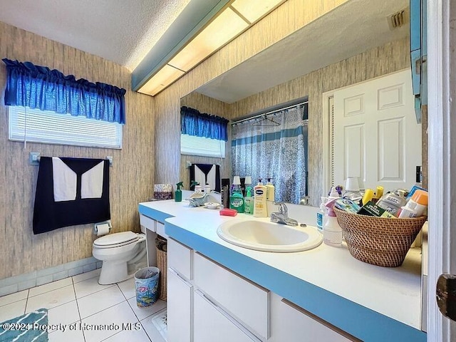 bathroom with toilet, tile patterned flooring, a textured ceiling, a shower with curtain, and vanity