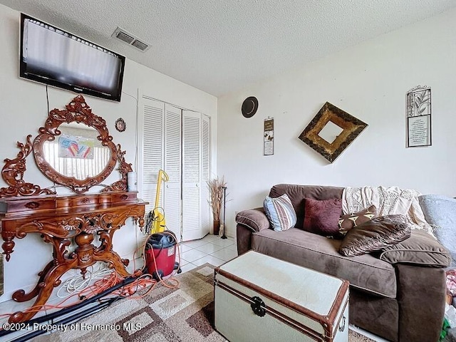 living room with a textured ceiling and light tile patterned floors