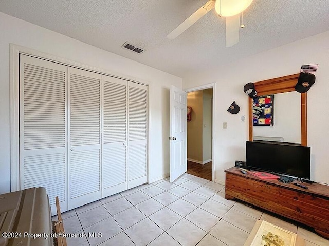 unfurnished bedroom featuring a closet, a textured ceiling, and ceiling fan