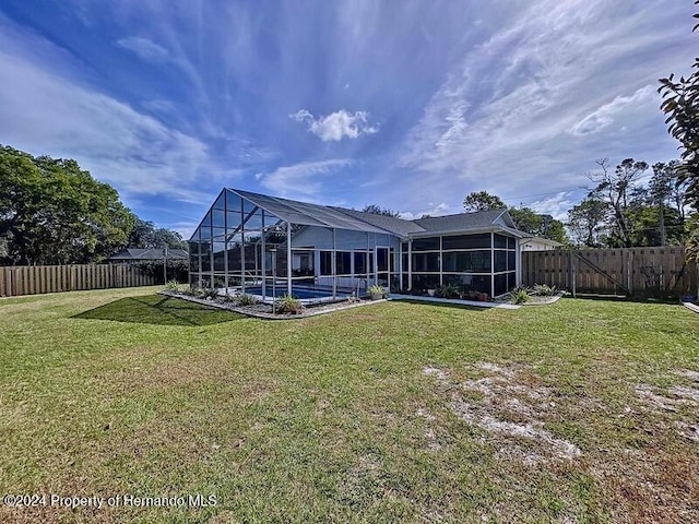 back of property featuring a lawn, glass enclosure, and a swimming pool