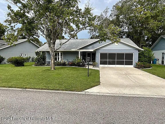 ranch-style house with a front yard and a garage