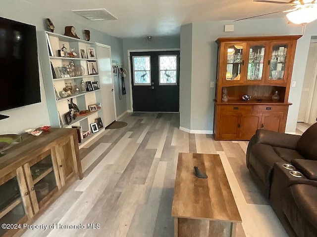 living room featuring ceiling fan, light hardwood / wood-style flooring, and french doors