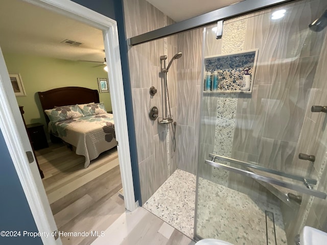 bathroom with walk in shower and wood-type flooring