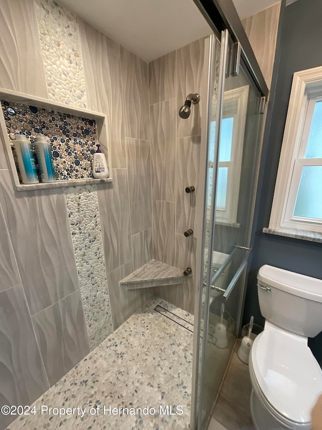 bathroom featuring toilet and tiled shower