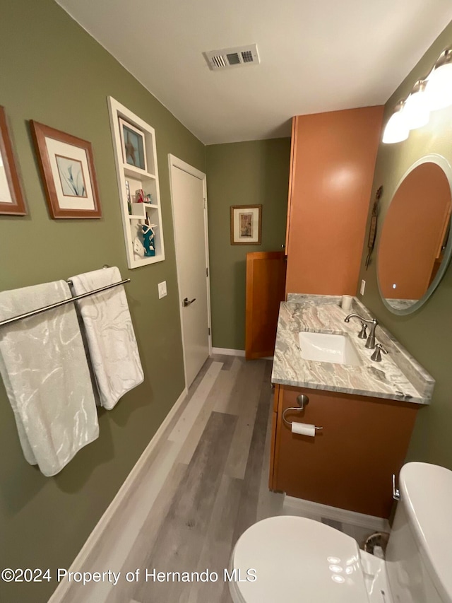 bathroom featuring hardwood / wood-style flooring, vanity, and toilet