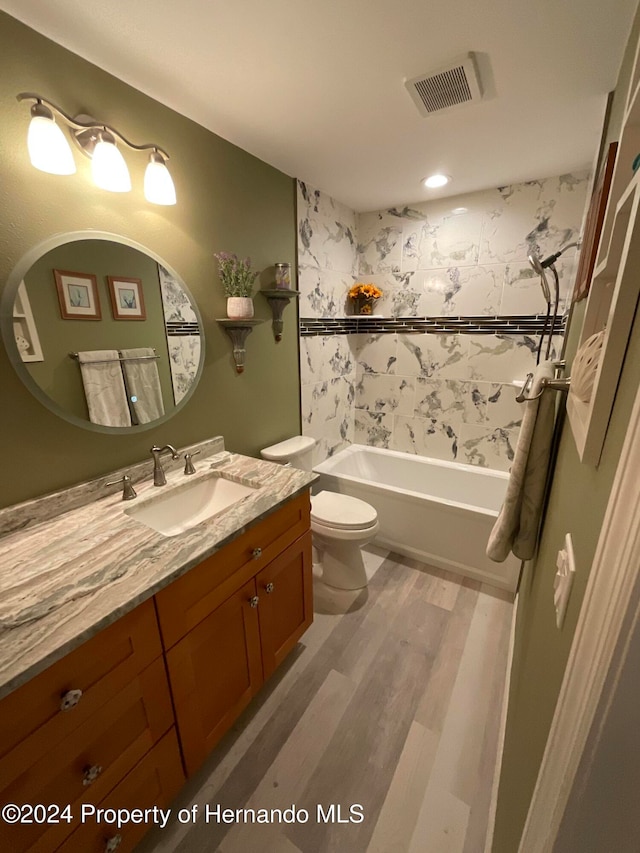 full bathroom with wood-type flooring, vanity, toilet, and shower / washtub combination