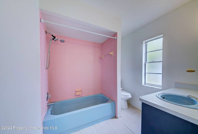 full bathroom featuring vanity, tiled shower / bath, tile patterned flooring, toilet, and a textured ceiling