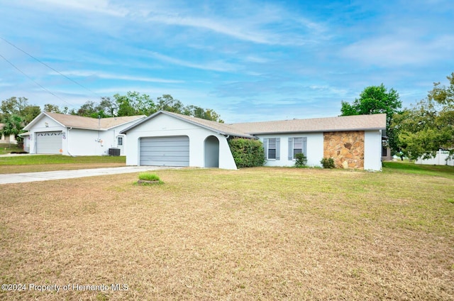 ranch-style home featuring a garage, central air condition unit, and a front yard