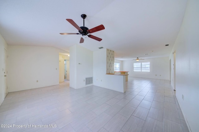 unfurnished living room with ceiling fan and vaulted ceiling