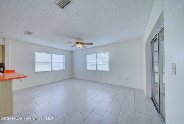 spare room with ceiling fan and a textured ceiling