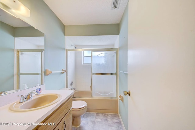 full bathroom with vanity, combined bath / shower with glass door, tile patterned flooring, toilet, and a textured ceiling