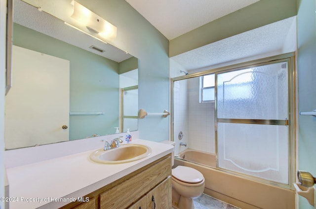 full bathroom featuring a textured ceiling, vanity, toilet, and bath / shower combo with glass door