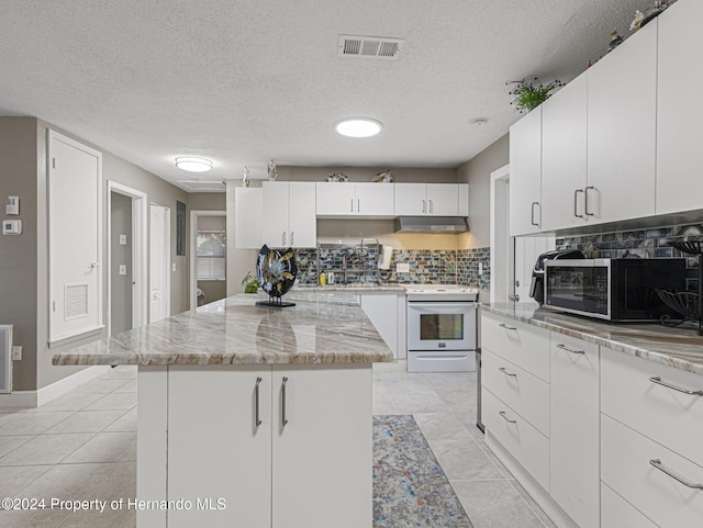 kitchen with white cabinets, white electric range, and a kitchen island