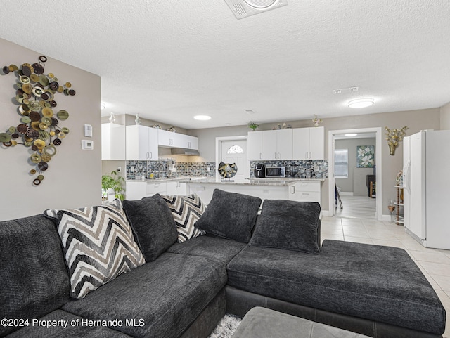 living room featuring a wealth of natural light, a textured ceiling, and light tile patterned flooring