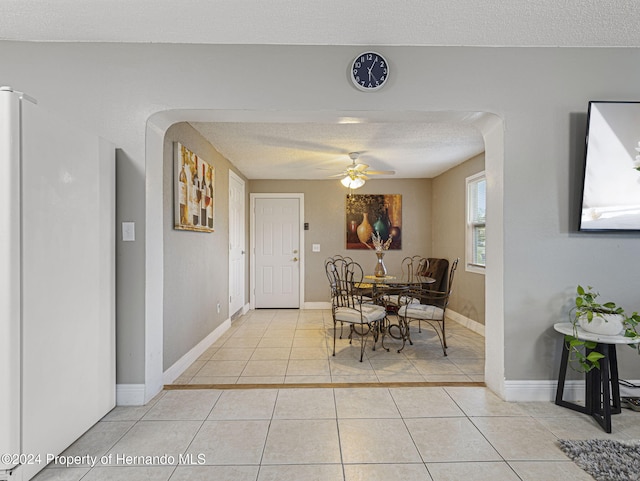 tiled dining area featuring a textured ceiling and ceiling fan