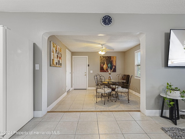 1009 Cobbelstone Dr, Spring Hill, FL 34606 - dining room featuring light tile patterned floors, a textured ceiling, baseboards, and ceiling fan