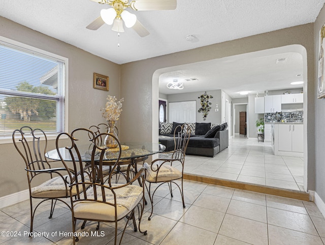 tiled dining area featuring a textured ceiling and ceiling fan