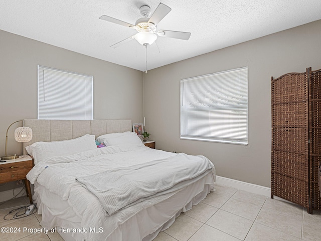 tiled bedroom with a textured ceiling and ceiling fan