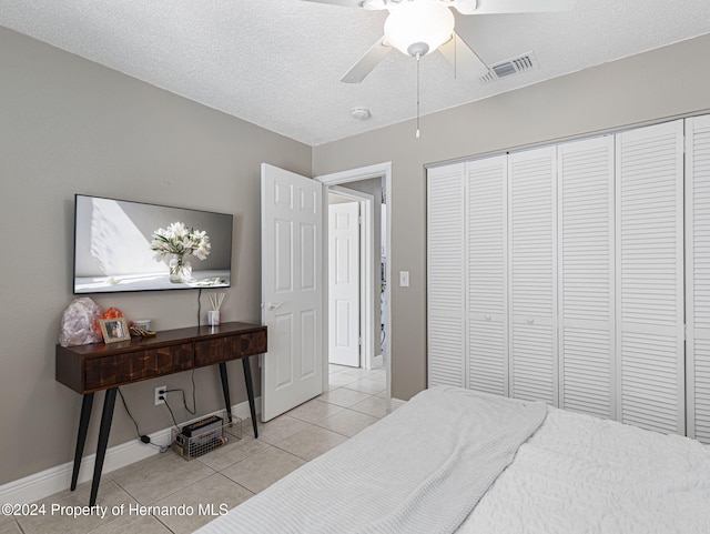 1009 Cobbelstone Dr, Spring Hill, FL 34606 - tiled bedroom featuring baseboards, a closet, ceiling fan, and a textured ceiling