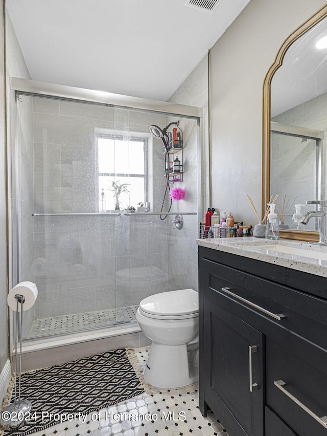 bathroom with vanity, an enclosed shower, and tile patterned floors