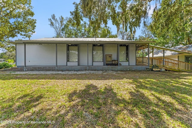 rear view of house featuring a yard