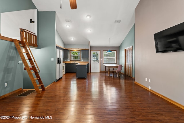 unfurnished living room featuring high vaulted ceiling, ceiling fan, and dark wood-type flooring