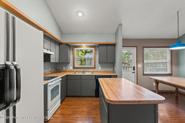 kitchen with vaulted ceiling, a center island, white range with electric cooktop, and plenty of natural light