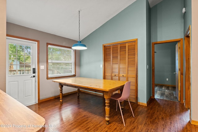 dining space with dark wood-type flooring and vaulted ceiling