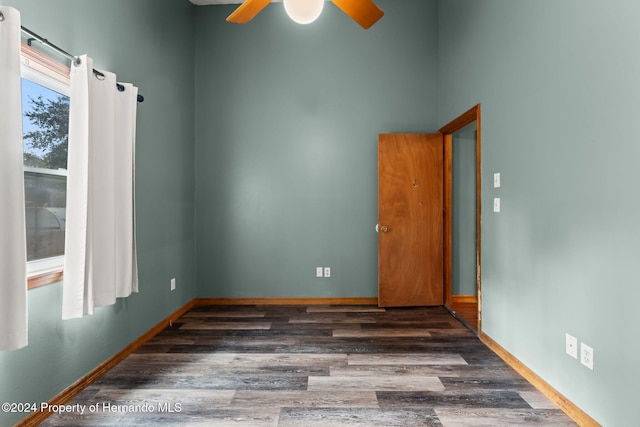 empty room with ceiling fan and dark hardwood / wood-style floors