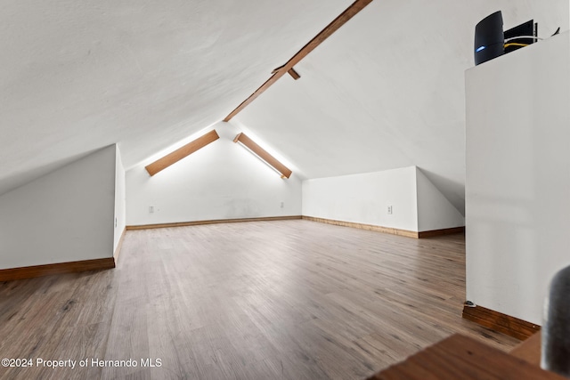 bonus room with hardwood / wood-style flooring and lofted ceiling