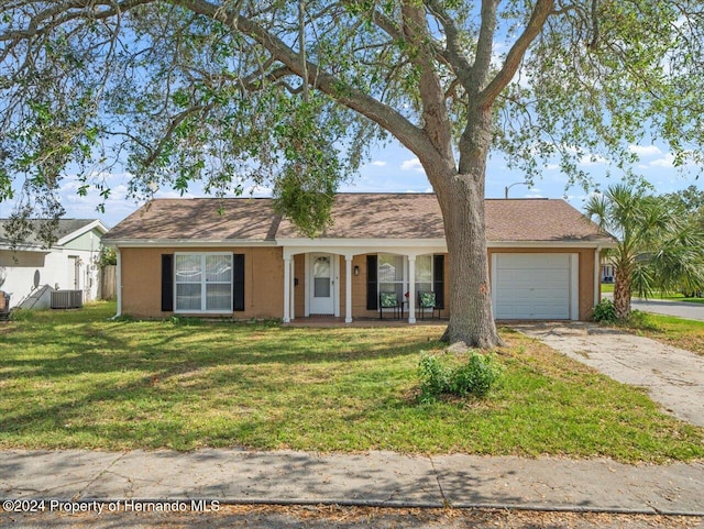 ranch-style house with central AC unit, a garage, covered porch, and a front lawn