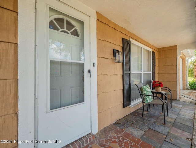 view of exterior entry featuring covered porch