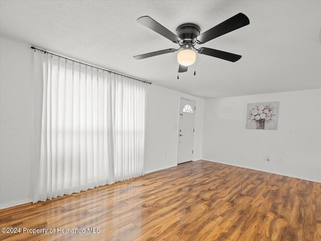 spare room featuring a textured ceiling, hardwood / wood-style flooring, and ceiling fan